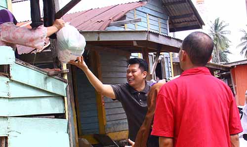 Aid workers in South East Asia loading parcels onto a van.