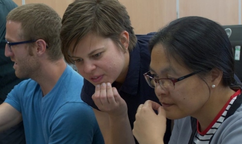 Three students concentrating on their work.