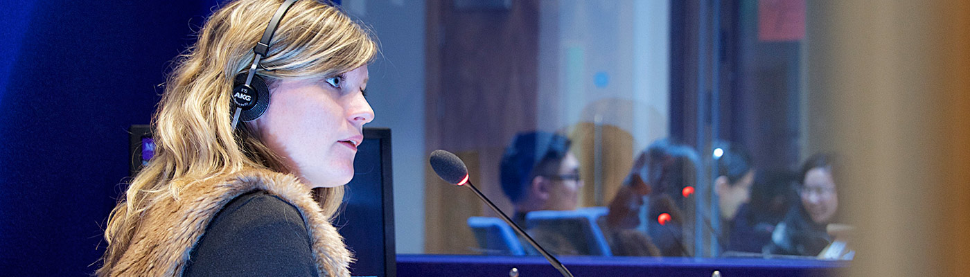 Female looking sideways at a desk with a microphone